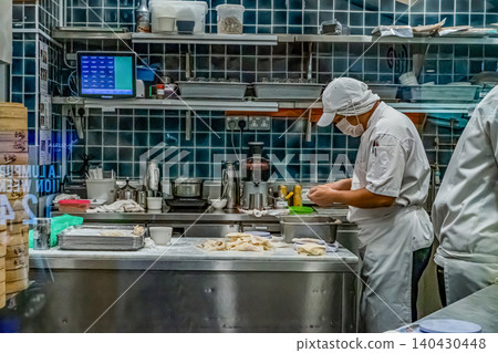 Asian chef preparing dumplings in busy kitchen Asian chef preparing dumplings in busy kitchen 140430448