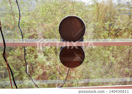 Double sided robotic window cleaner attached to glass working on outdoor window surface with water droplets Double sided robotic window cleaner attached to glass working on outdoor window surface with water droplets 140430811