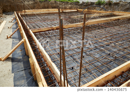 Reinforced concrete foundation preparation with steel rebar grid and wooden formwork Reinforced concrete foundation preparation with steel rebar grid and wooden formwork 140430875