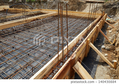 Reinforced concrete foundation with steel rebar grid and wooden formwork Reinforced concrete foundation with steel rebar grid and wooden formwork 140430884