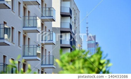 European residential architecture harmonizing with nature. Eco-friendly living in city with greens. Eco apartment building saving energy and fresh air concept. European residential architecture harmonizing with nature. Eco-friendly living in city with greens. Eco apartment building saving energy and fresh air concept. 140431086