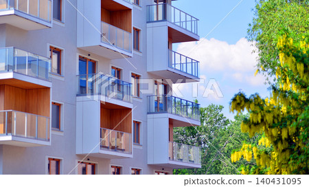 European residential architecture harmonizing with nature. Eco-friendly living in city with greens. Eco apartment building saving energy and fresh air concept. European residential architecture harmonizing with nature. Eco-friendly living in city with greens. Eco apartment building saving energy and fresh air concept. 140431095