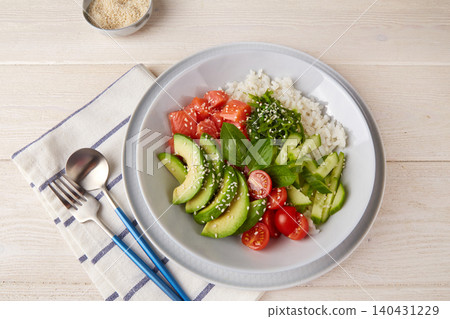 Hawaiian salmon poke bowl with cucumber, tomato,rice, chuka salad, sesame seeds, avocado. Hawaiian salmon poke bowl with cucumber, tomato,rice, chuka salad, sesame seeds, avocado. 140431229