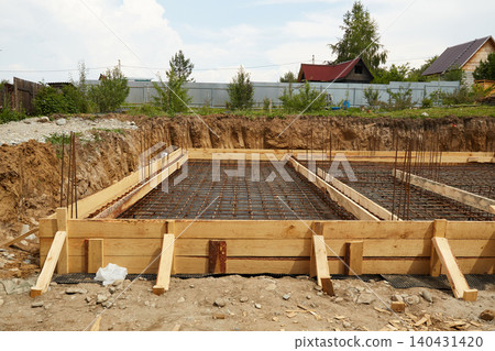 Steel reinforcement is placed in wooden molds and formwork on a construction site Steel reinforcement is placed in wooden molds and formwork on a construction site 140431420