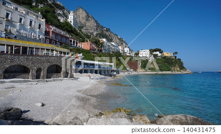 Public beach with turquoise water on Capri Island. Travel destinations and luxury vacations concept Public beach with turquoise water on Capri Island. Travel destinations and luxury vacations concept 140431475