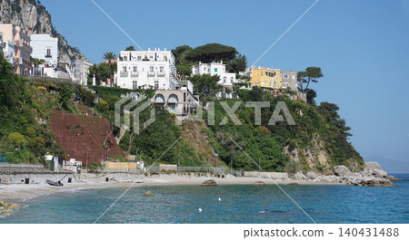 Public beach with turquoise water on Capri Island. Travel destinations and luxury vacations concept Public beach with turquoise water on Capri Island. Travel destinations and luxury vacations concept 140431488