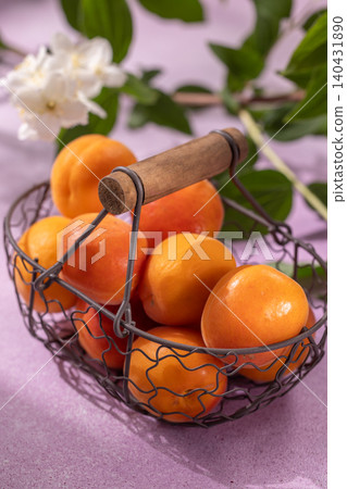 Fresh summer apricots filling rustic metal basket Fresh summer apricots filling rustic metal basket 140431890