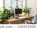 A minimalist home office setup with wooden desk decorated with green plant 140432090