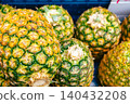 Close-up of fresh pineapples displayed in a shop window (with a fruit texture background) 140432208