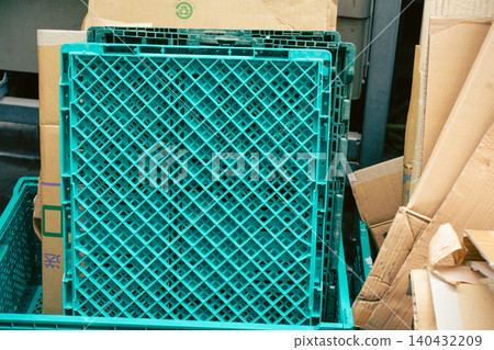 Blue-green folding containers (Oricon) and bundled cardboard boxes placed in the back room Blue-green folding containers (Oricon) and bundled cardboard boxes placed in the back room 140432209