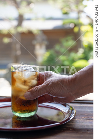 A hand holding a glass of barley tea A hand holding a glass of barley tea 140432943