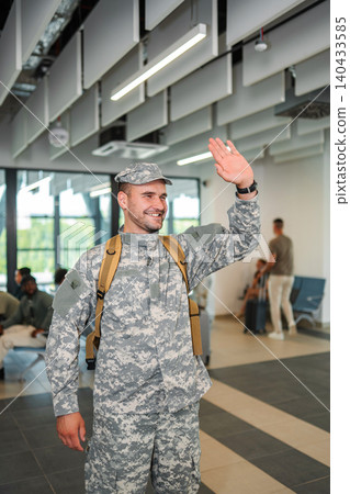 Soldier in camouflage uniform waving at airport terminal Soldier in camouflage uniform waving at airport terminal 140433585