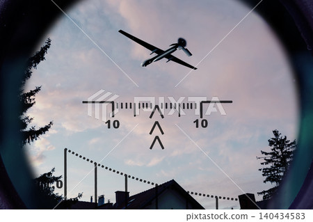 Reconnaissance drone flies above residential buildings and is observed through optical scope. Reconnaissance drone flies above residential buildings and is observed through optical scope. 140434583