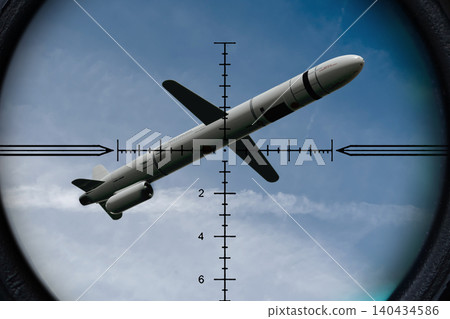 Cruise missile is positioned in center of targeting reticle against sky. 140434586