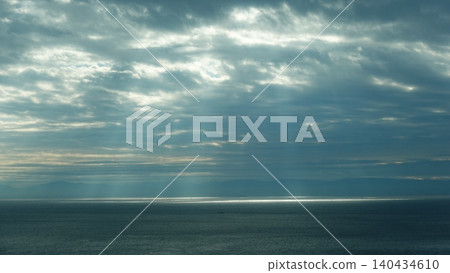 Crepuscular rays pouring down onto the sea surface through gaps in the clouds. Crepuscular rays pouring down onto the sea surface through gaps in the clouds. 140434610