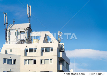Cell phone base station antenna and water storage tank on the roof of an apartment building Cell phone base station antenna and water storage tank on the roof of an apartment building 140434850