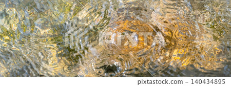 The background is a sparkling water surface over rocky shores, evoking a summery image. The background is a sparkling water surface over rocky shores, evoking a summery image. 140434895