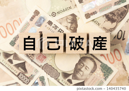 A block with "Personal Bankruptcy" written on it and lots of 10,000 yen bills. A block with "Personal Bankruptcy" written on it and lots of 10,000 yen bills. 140435740