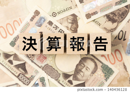 A block labeled "Financial Report" and a large number of 10,000 yen bills. A block labeled "Financial Report" and a large number of 10,000 yen bills. 140436128