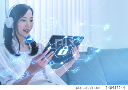 一名女子正在使用平板電腦操作保全系統。 一名女子正在使用平板電腦操作保全系統。 140436244