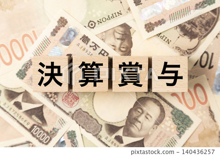 A block with "Year-End Bonus" written on it and lots of 10,000 yen bills. A block with "Year-End Bonus" written on it and lots of 10,000 yen bills. 140436257