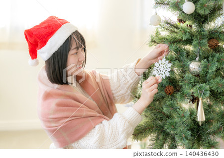 Woman decorating the Christmas tree 140436430