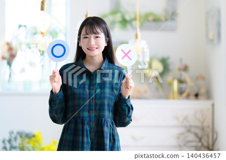 一位年輕女子用○×符號表達自己的觀點。 一位年輕女子用○×符號表達自己的觀點。 140436457