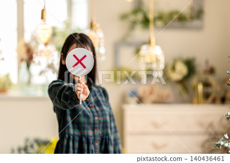 一名女子舉起「X」標誌表達自己的意見。 140436461