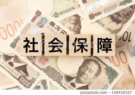 一塊寫著「社會安全」字樣的鈔票和許多10,000日圓面額的鈔票。 一塊寫著「社會安全」字樣的鈔票和許多10,000日圓面額的鈔票。 140436587