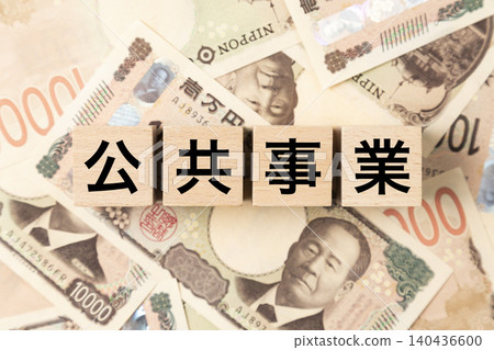 一塊寫著「公共工程」字樣的磚塊，以及許多10,000日圓的鈔票。 140436600