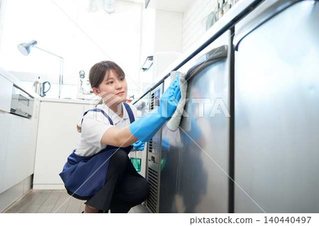 Female staff cleaning kitchen equipment Female staff cleaning kitchen equipment 140440497