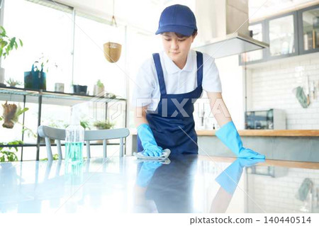Table wiping by young female cleaning staff Table wiping by young female cleaning staff 140440514