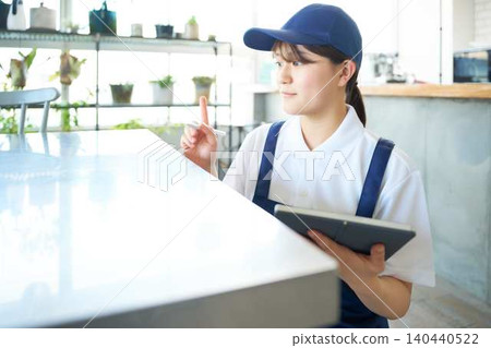 A young female house cleaning staff member checks the items. A young female house cleaning staff member checks the items. 140440522