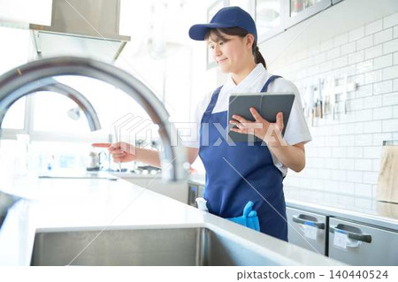A young cleaning staff member performs a point-and-call check. A young cleaning staff member performs a point-and-call check. 140440524