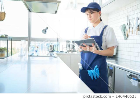 Female staff member using digital device for work management Female staff member using digital device for work management 140440525