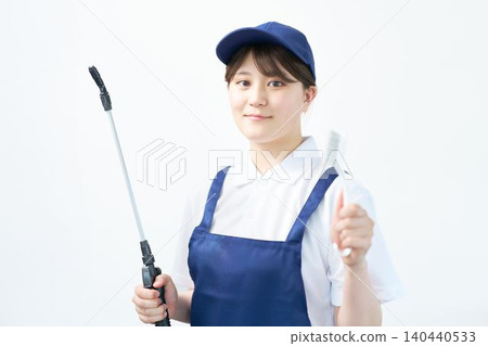Portrait of a female staff member holding cleaning supplies Portrait of a female staff member holding cleaning supplies 140440533