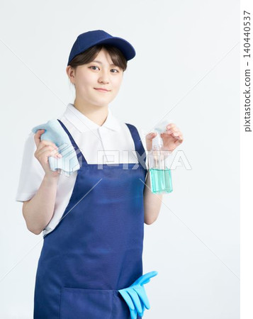 Portrait of a female staff member holding cleaning supplies 140440537