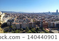 A panoramic view of Barcelona under a blue sky, including the Sagrada Familia's Nativity Facade and the cityscape from the tower. 140440901