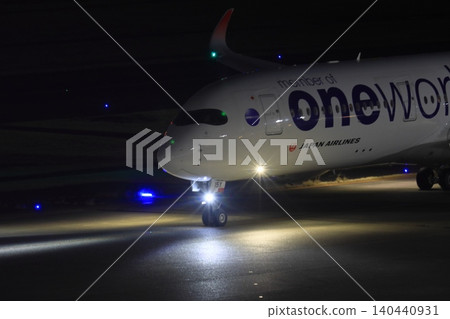 A passenger plane with its lights on heads towards its gate; an international flight is arriving. A passenger plane with its lights on heads towards its gate; an international flight is arriving. 140440931