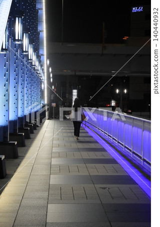 A woman walking on a lit-up bridge A woman walking on a lit-up bridge 140440932
