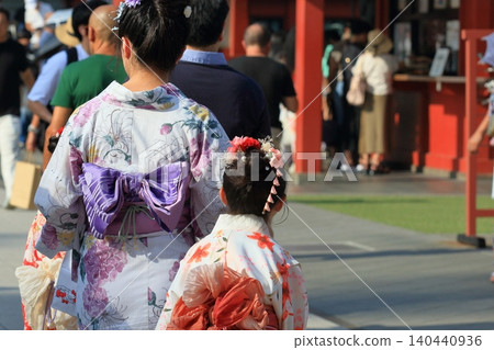 Tourists in yukata; a parent and child in rented kimonos. Tourists in yukata; a parent and child in rented kimonos. 140440936