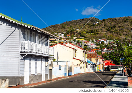 View of colorful creole architecture and traditional wooden houses on a sunny street in the village of Les Anses d'Arlet, Martinique, Caribbean France 140441005