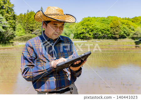 Senior farmers using tablets to practice smart farming. Senior farmers using tablets to practice smart farming. 140441023