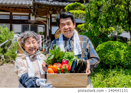 一對日本老農夫夫婦手持剛採摘的蔬菜 一對日本老農夫夫婦手持剛採摘的蔬菜 140441131