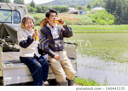 一對年長的農民夫婦在插秧間隙休息。 一對年長的農民夫婦在插秧間隙休息。 140441135