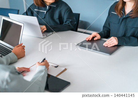 Men and women in work clothes using computers in a company/office setting (business negotiations, strategy, analysis, marketing) 140441145
