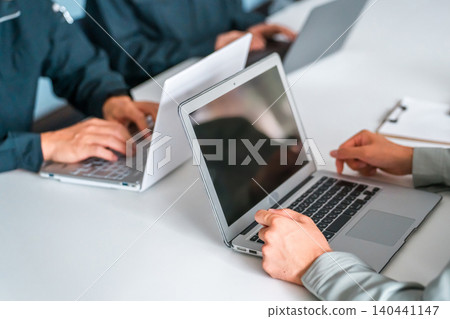 Men and women in work clothes using computers in a company/office setting (business negotiations, strategy, analysis, marketing) Men and women in work clothes using computers in a company/office setting (business negotiations, strategy, analysis, marketing) 140441147