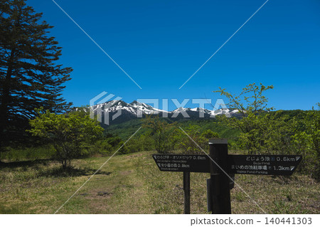 A view of snow-capped Mt. Norikura and an information sign from Norikura Plateau in early summer. A view of snow-capped Mt. Norikura and an information sign from Norikura Plateau in early summer. 140441303
