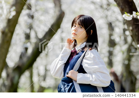 一張春日肖像照,一位高中女生漫步在櫻花盛開的街道上。 一張春日肖像照,一位高中女生漫步在櫻花盛開的街道上。 140441334