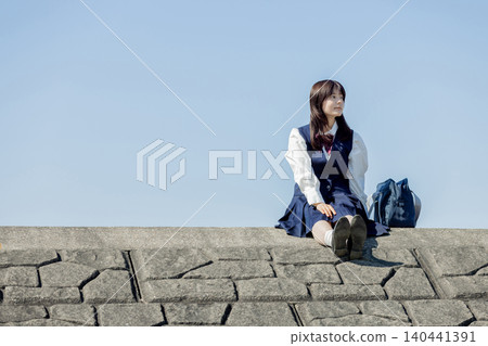 A high school girl gazes up at the blue sky, imagining the future. A high school girl gazes up at the blue sky, imagining the future. 140441391